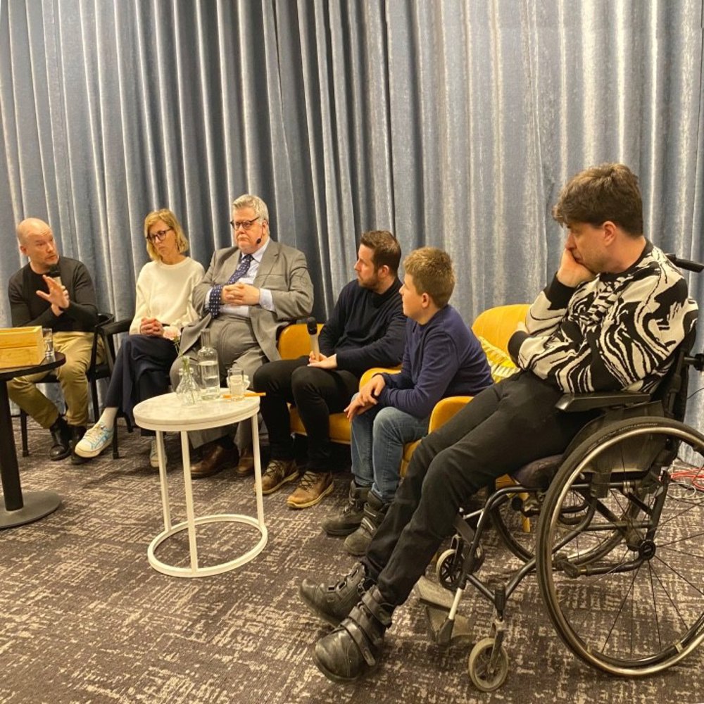 Panellister sittandes runt ett runt bord