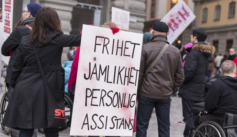 Demonstration med skylt där det står 'Frihet, jämlikhet, personlig assistans.