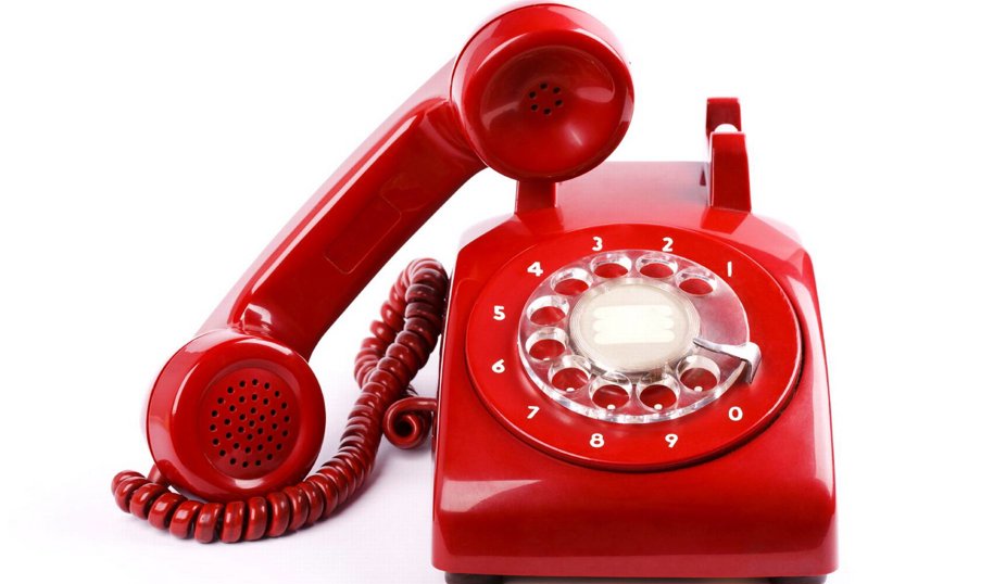 Röd gammaldags telefon med nummerskiva och luren avlyft.