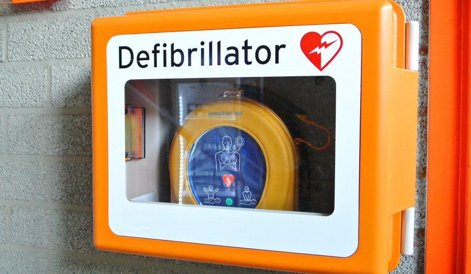 Hjärtstartare i orange väggskåp monterad på en vägg.